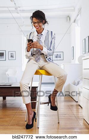 Smiling Mixed Race woman texting on cell phone View Large Photo Image Stock Image - Smiling Mixed Race woman texting on cell phone. Fotosearch