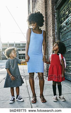 Smiling mother and daughters standing on sidewalk View Large Photo Image Stock Photography - Smiling mother and daughters standing on sidewalk. Fotosearch