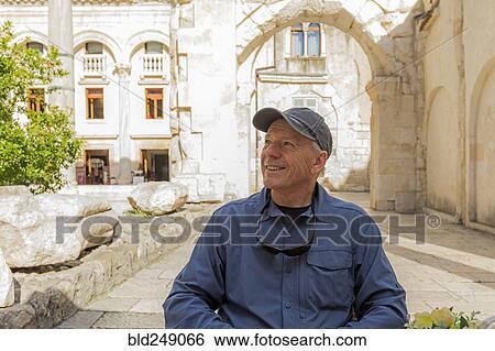 Smiling older Caucasian man sitting in garden View Large Photo Image Stock Photograph - Smiling older Caucasian man sitting in garden. Fotosearch