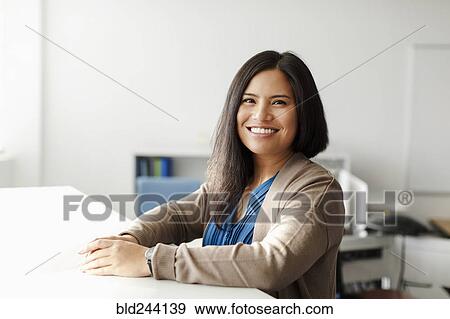 Smiling Pacific Islander woman in office View Large Photo Image Stock Photo - Smiling Pacific Islander woman in office. Fotosearch