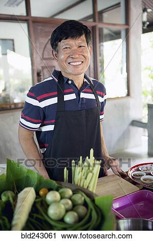 Smiling Thai man preparing food View Large Photo Image Stock Image - Smiling Thai man preparing food. Fotosearch