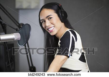 Stock Image - Smiling Thai transgender woman at microphone. Fotosearch