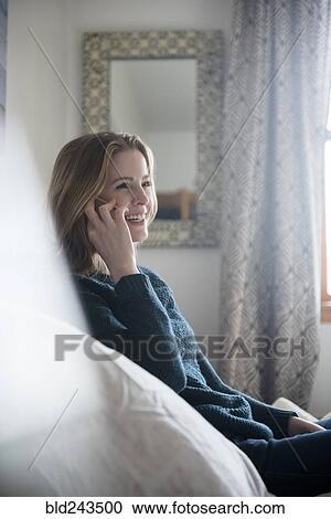 Stock Image - Smiling woman talking on cell phone. Fotosearch