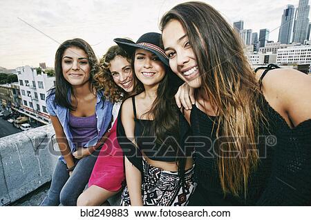 Stock Image - Smiling women on urban rooftop. Fotosearch