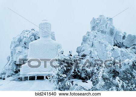 Stock Image - Snow on Buddha statue. Fotosearch