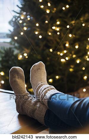 Socks of Caucasian woman with feet on table near Christmas tree View Large Photo Image Stock Image - Socks of Caucasian woman with feet on table near Christmas tree. Fotosearch