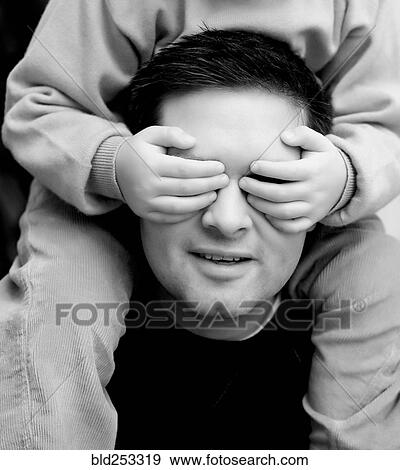 Son covering eyes of father View Large Photo Image Stock Photo - Son covering eyes of father. Fotosearch