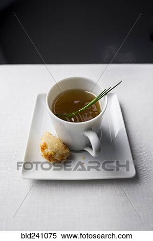 Stock Photography - Spring of herb in cup of broth with bread. Fotosearch