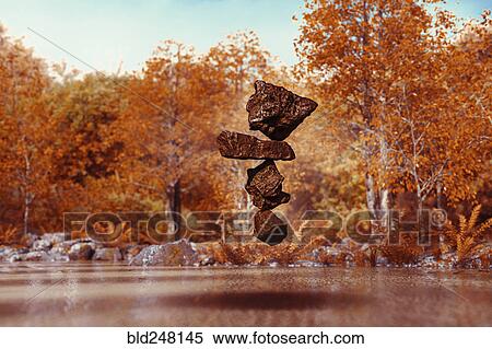 Stock Photography - Stack of balancing rocks hovering mid-air in autumn. Fotosearch