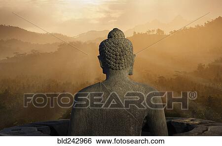 Stock Photograph - "Statue of Buddha at sunset, Borobudur, Java, Indonesia". Fotosearch