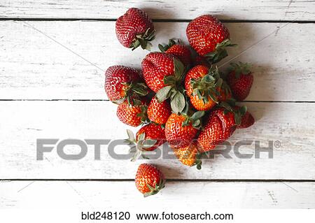 Stock Image - Strawberries on wooden table. Fotosearch