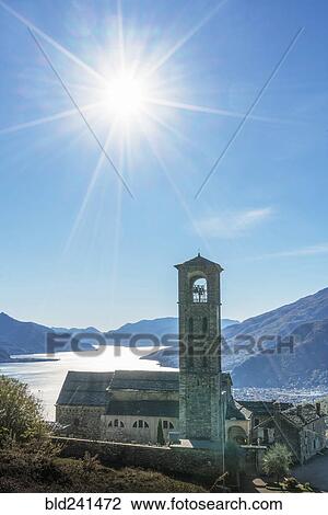 Stock Image - Sun in blue sky over Gravedona, Lake Como, Italy. Fotosearch