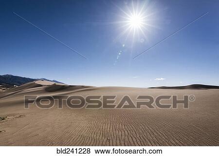 Sun in blue sky over sand dunes View Large Photo Image Stock Photo - Sun in blue sky over sand dunes. Fotosearch