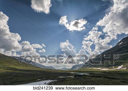 Sunbeams over river in remote valley View Large Photo Image Stock Photo - Sunbeams over river in remote valley. Fotosearch