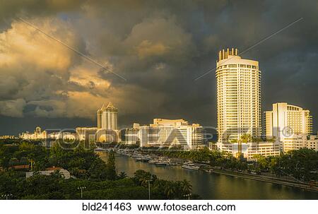 Stock Image - Sunset on boats at urban waterfront. Fotosearch