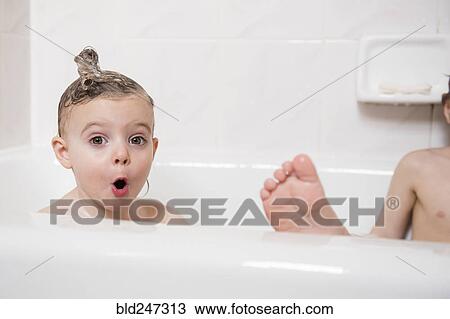Stock Image - Surprised Caucasian girl in bubble bath. Fotosearch