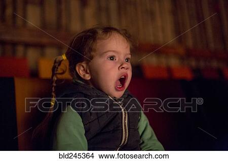 Surprised Caucasian girl watching movie in theater View Large Photo Image Picture - Surprised Caucasian girl watching movie in theater. Fotosearch