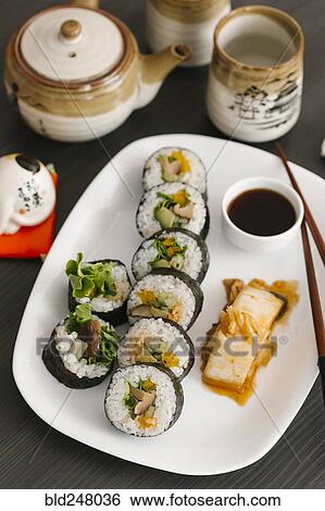 Stock Photograph - Sushi on plate with sauce and chopsticks. Fotosearch