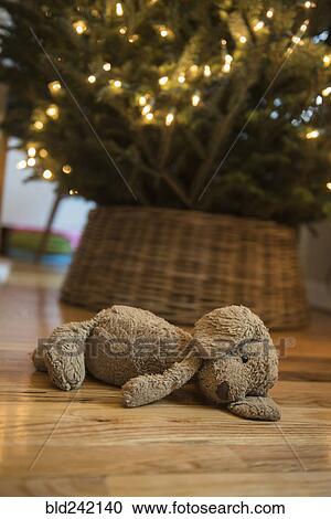 Teddy bear laying on floor near Christmas tree View Large Photo Image Stock Image - Teddy bear laying on floor near Christmas tree. Fotosearch