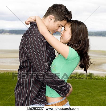Stock Photo - Teenage couple hugging outdoors. Fotosearch