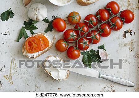 Tomatoes on vine near cream cheese and bread View Large Photo Image Stock Photograph - Tomatoes on vine near cream cheese and bread. Fotosearch