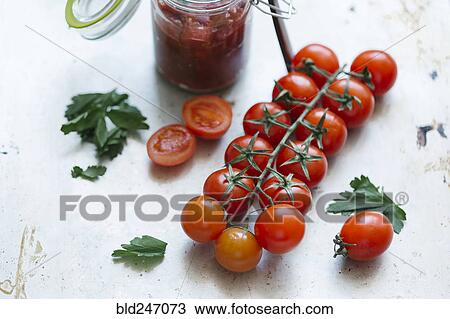 Tomatoes on vine near jar View Large Photo Image Stock Image - Tomatoes on vine near jar. Fotosearch