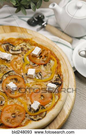 Stock Image - Tomatoes with peppers and cheese on pizza. Fotosearch