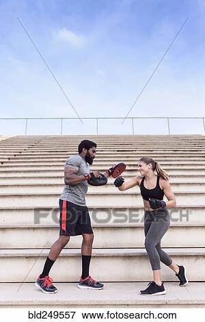 Trainer and woman boxing on bleachers View Large Photo Image Stock Photo - Trainer and woman boxing on bleachers. Fotosearch