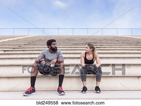 Trainer and woman resting on bleachers View Large Photo Image Stock Photo - Trainer and woman resting on bleachers. Fotosearch