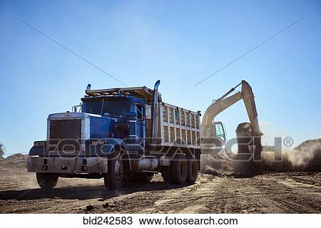 Truck near digger in dirt field View Large Photo Image Stock Image - Truck near digger in dirt field. Fotosearch