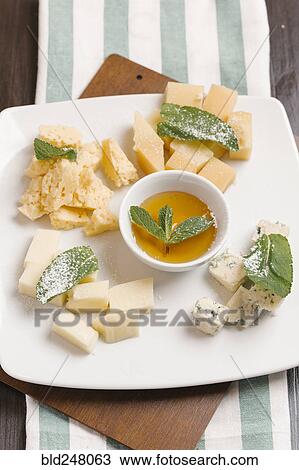 Variety of cheeses on plate with sauce View Large Photo Image Stock Image - Variety of cheeses on plate with sauce. Fotosearch