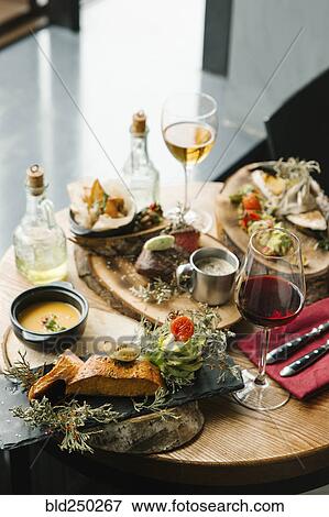 Stock Photo - Variety of meat and fish on table with wine. Fotosearch