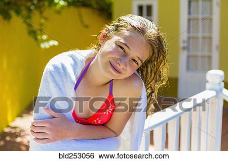 Stock Photograph - Wet Caucasian girl leaning on railing. Fotosearch