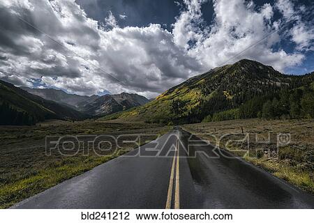 Wet two-lane road near mountains View Large Photo Image Stock Image - Wet two-lane road near mountains. Fotosearch
