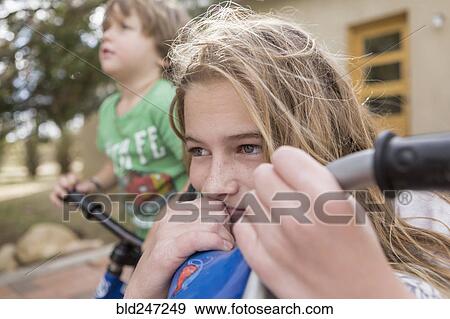 Stock Photo - Wind blowing hair of Caucasian girl on bicycle. Fotosearch