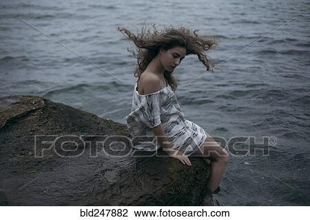 Wind blowing hair of Caucasian girl sitting at ocean View Large Photo Image Stock Image - Wind blowing hair of Caucasian girl sitting at ocean. Fotosearch