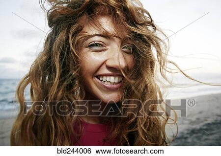Stock Photograph - Wind blowing hair of Caucasian woman on beach. Fotosearch