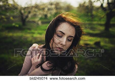 Picture - Wind blowing hair of pensive Caucasian woman. Fotosearch