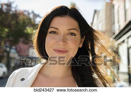 Stock Photo - Wind blowing hair of smiling Caucasian woman. Fotosearch