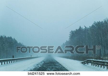Stock Photography - Wind on tree-lined winter road. Fotosearch