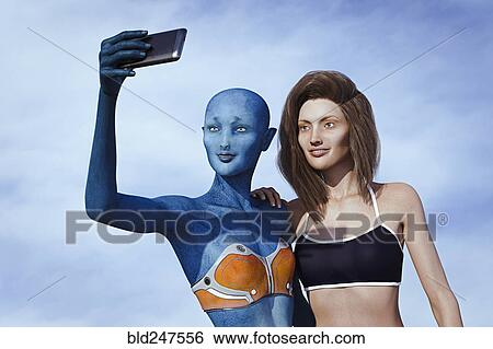 Stock Photograph - Woman and alien posing for cell phone selfie. Fotosearch