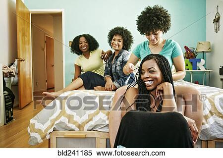 Woman braiding hair of friend in bedroom View Large Photo Image Stock Photography - Woman braiding hair of friend in bedroom. Fotosearch