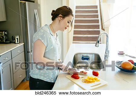 Woman chopping food in domestic kitchen View Large Photo Image Stock Photography - Woman chopping food in domestic kitchen. Fotosearch