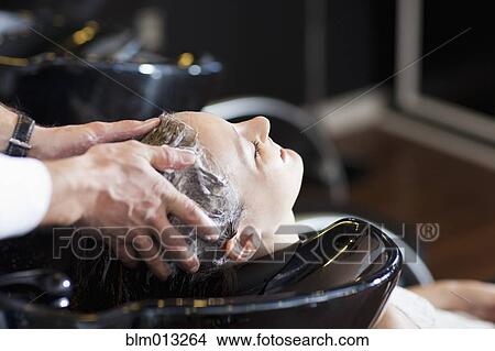 Picture - Woman having her hair washed in salon. Fotosearch