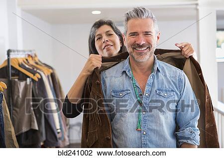 Woman helping man with fringe jacket in store View Large Photo Image Stock Image - Woman helping man with fringe jacket in store. Fotosearch