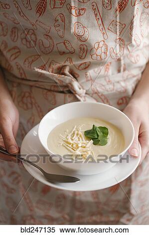 Stock Photography - Woman holding bowl of cheese soup. Fotosearch