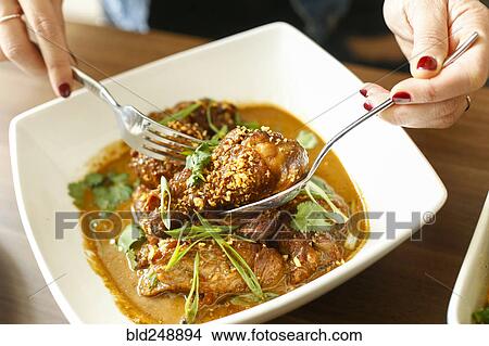 Woman holding meet in bowl with fork and spoon View Large Photo Image Picture - Woman holding meet in bowl with fork and spoon. Fotosearch