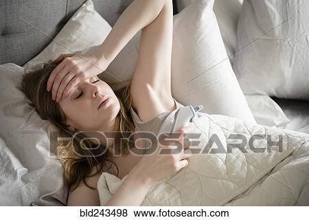 Stock Photo - Woman laying in bed with headache. Fotosearch