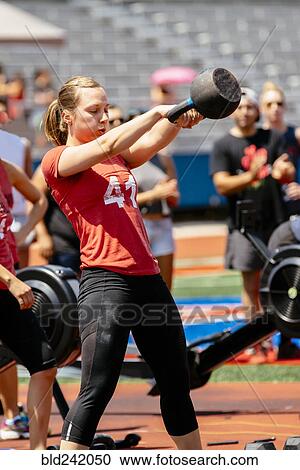 Woman lifting kettlebell outdoors View Large Photo Image Stock Image - Woman lifting kettlebell outdoors. Fotosearch