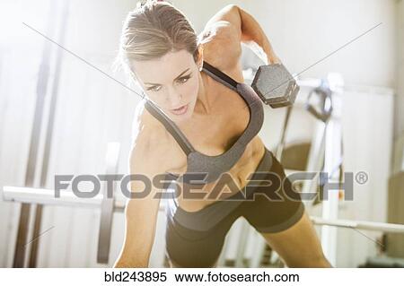 Woman lifting weights in gymnasium View Large Photo Image Stock Photography - Woman lifting weights in gymnasium. Fotosearch